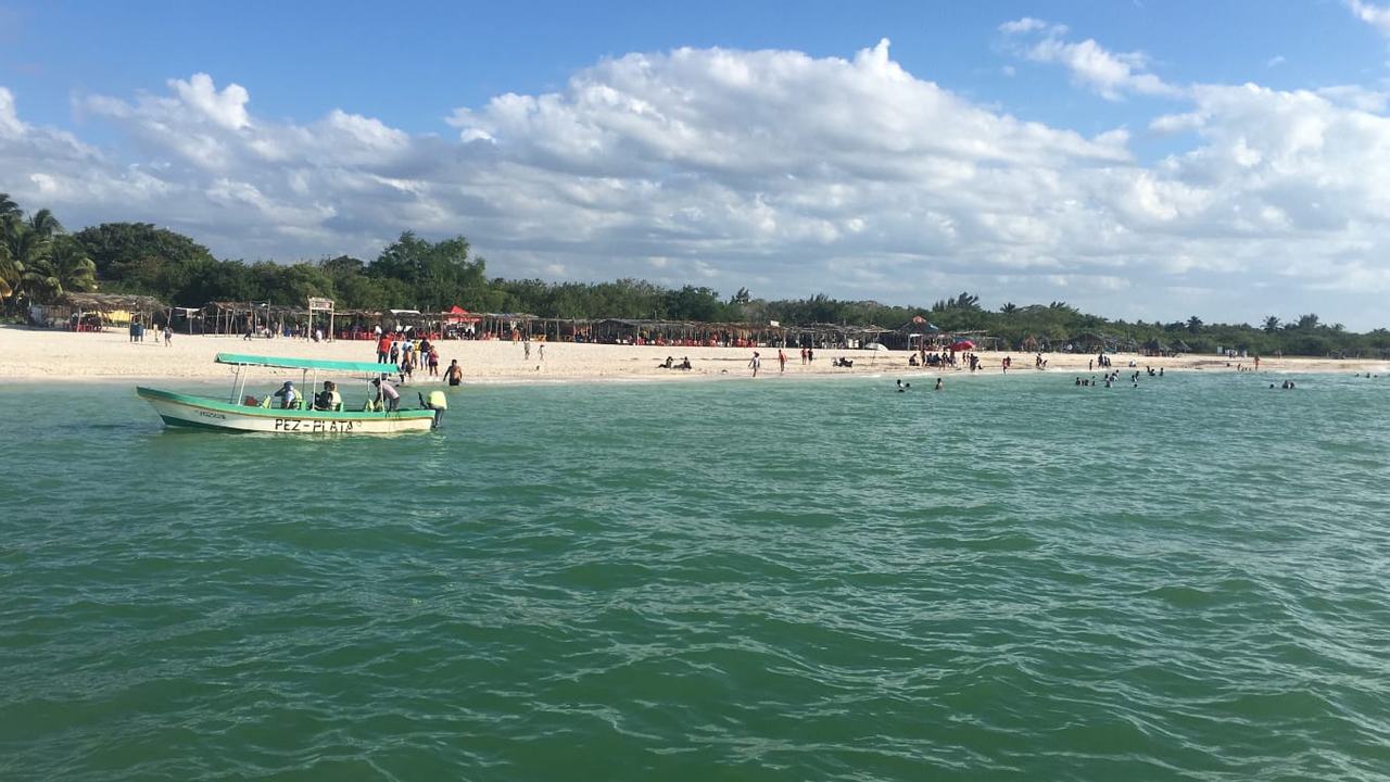 Lancha frente a la playa y las palapas de Celestún
