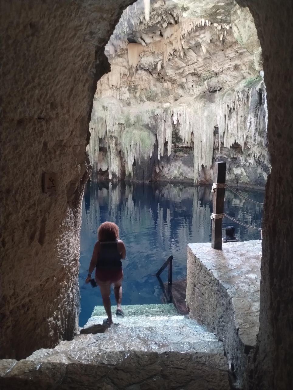 Bajando a un cenote por un arco de piedra