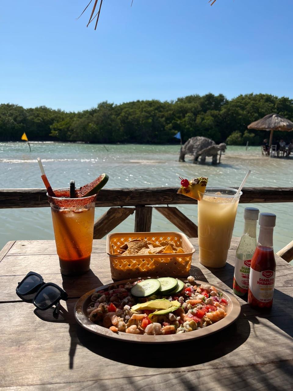 Ceviche y bebidas frente al agua en Islas Columpios